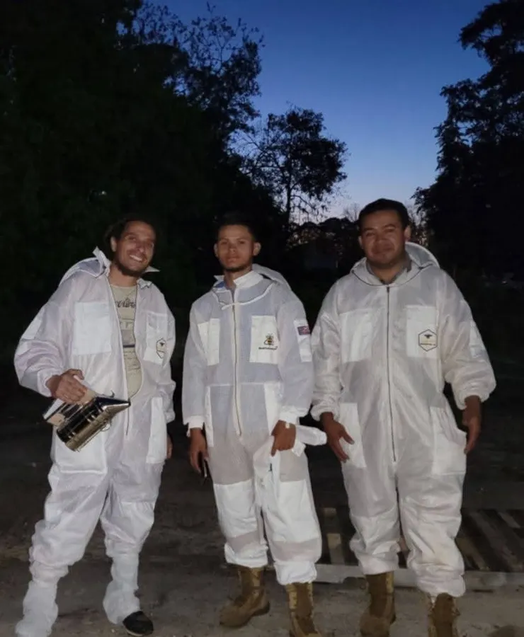 The Blackwater Bee Ranch crew in suits at dusk after a day in the yard